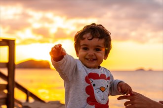 Boy laughing at sunset in Cala Comte beach on the island of Ibiza. Balearic