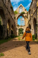 A young woman visiting the ruins of the Abbaye de Beauport church in the village of Paimpol