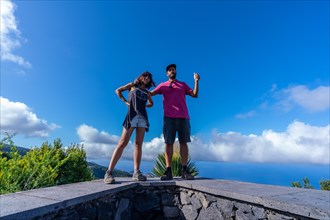 A very happy couple on top of the mountain at the viewpoint of the Cubo de la Galga natural park on the northeast coast on the island of La Palma