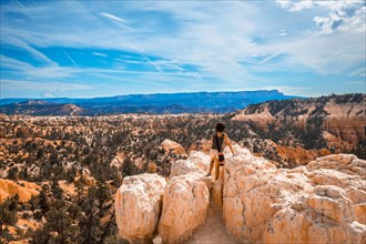 A girl sitting looking at the views from the Sunrise Point in Bryce National Park. Utah