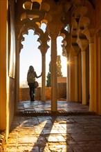 A young woman at sunset from the Arab doors of a courtyard of the Alcazaba in the city of Malaga