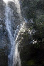 Water splashing against rocks in sunlit waterfall in Minas Gerais
