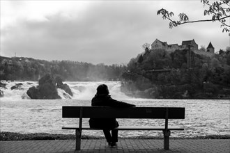 Woman Sitting on a Bench in Front of Rhine Falls at Neuhausen in Schaffhausen