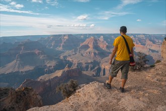 A man in a yellow shirt enjoying the sunset views at Mojave Point in Grand Canyon. Arizona