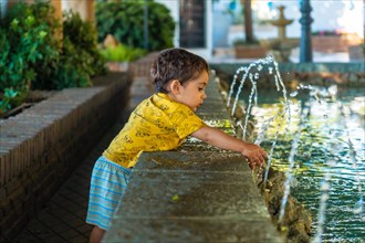 A baby cooling off from the heat in the fountain in the municipality of Mijas in Malaga. Andalusia