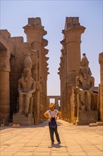 A young tourist with a hat visiting the Egyptian Temple of Luxor and its beautiful columns. Egypt