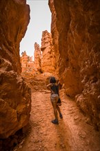A young woman starting the rise of the Navajo Loop Trail in Bryce National Park