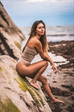 Caucasian brunette with a brown swimsuit at the seaside in the town of Zumaia