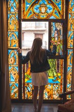 Young blonde caucasian woman in a white dress and denim jacket enjoying a beautiful medieval hotel in the town of Olite in Navarra. Spain
