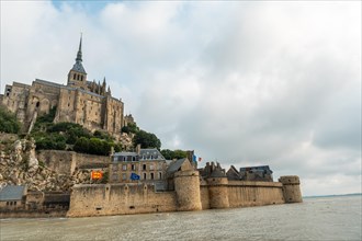 The famous Mont Saint-Michel Abbey at sunrise at high tide in the Manche department