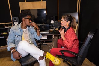 Frontal photo of two musicians talking relaxed during a break in a recording studio
