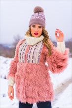 Portrait of young blonde model wearing pink fur jacket