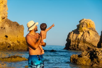 A father with his son on vacation at Praia dos Arrifes