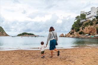 A mother with her son on the beach in the port of San Miquel on the island of Ibiza. Balearic Islands