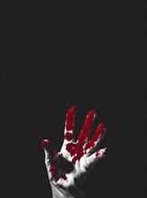Reaching up hand in white glove with blood stains