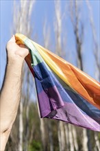 Closeup of male arm holding lgbt rainbow flag