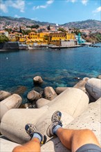 Sitting looking at yellow fort by the sea from Forte de Sao Tiago on Funchal beach. Madeira