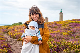 A mother next to the flowers in summer in Phare Du Cap Frehel