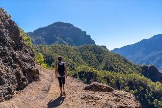 A young woman walking on the trek to the top of La Cumbrecita on the trail next to the Caldera de Taburiente motanas