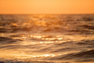Ocean on sunset backlit with sun defocused blurred background