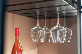 Empty wine glasses hanging on a stand kitchen furniture. Mid shot