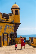 A tourist in summer walking with her baby inside the Forte de Sao Tiago in Funchal. Madeira