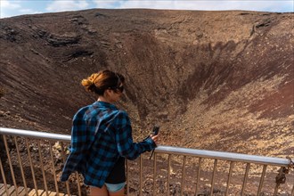 A young tourist visiting the Crater of the Calderon Hondo volcano near Corralejo