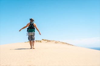 A young man walking with his son on the sand dune on Monsul beach in the Cabo de Gata Natural Park