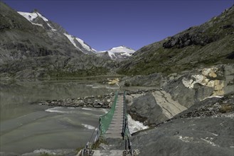 Bridge at the glacier lake in the Grossglockner area with Grossglockner
