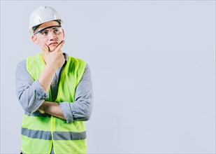 Pensive male engineer with hand on chin isolated. Pensive man engineer looking side. Portrait of handsome engineer thinking with hand on chin