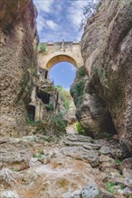 Stone bridge over a cliff with a dry riverbed running underneath. in ronda