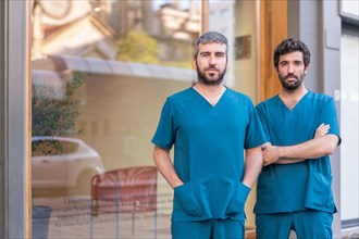 Horizontal photo with copy space of two serious medical team standing in the entrance of a the clinic
