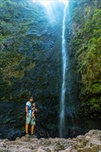 A father with his son at the waterfall at Levada do Caldeirao Verde