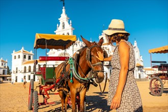 A tourist caressing a horse in the El Rocio sanctuary at the Rocio festival