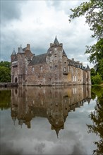 Reflections of the medieval Chateau Trecesson in the lake