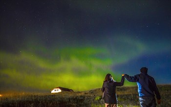 A couple in Northern lights in the sky on the Reykjanes peninsula in southern Iceland