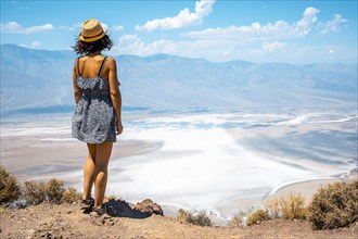 A young woman in dress on the beautiful viewpoint of Dante's view in Death Valley