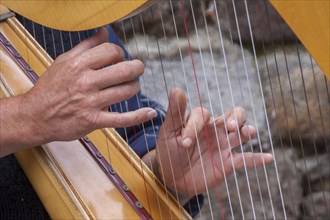Hands playing a harp