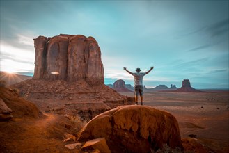 A boy in a white T-shirt in the sunset inside Monument Valley National Park. Utah