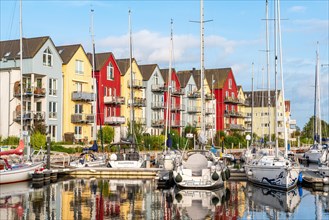 Sailing yachts and colourful houses with holiday flats in the harbour of Greifswald