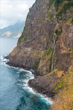 Waterfall into the sea at the Miradouro do Veu da Noiva viewpoint in Madeira. Portugal