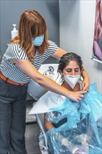 Hairdresser with face mask removing the protective plastic. Safety measures for hairdressers in the Covid-19 pandemic. New normal