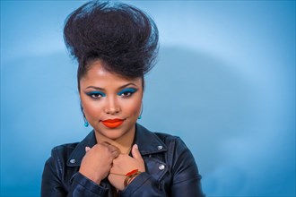 A closeup portrait of a fashion attractive rocker style woman with bright makeup wearing a leather jacket