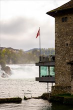 Rhine Falls and Swiss Flag with a Building at Neuhausen