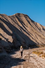A young hiker with backpack and hat in the desert of Tabernas