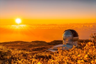 Astronomical Observatory of the Caldera de Taburiente in a beautiful orange sunset with the sun above
