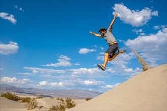 A young man jumping in desert on a summer afternoon in Death Valley