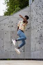 Vertical photo of a african american man jumping high outdoors