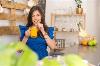 Woman enjoying a fresh orange juice in the counter of a cafeteria
