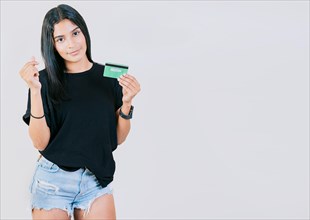 Girl holding credit card making money gesture with fingers isolated